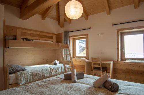 a bedroom with two bunk beds and a chandelier at Begale - Rifugio Urbano in Rotzo