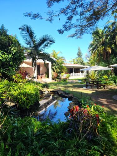a garden with a pond in front of a house at Mijn Kitchen Coffee Shop and B&B in Blantyre