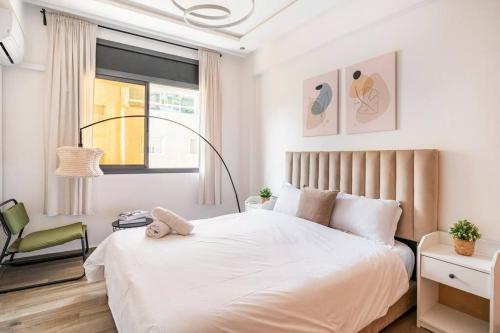 a bedroom with a white bed and a chair at TT Holidays Cosy apartment Rabat City Center in Rabat