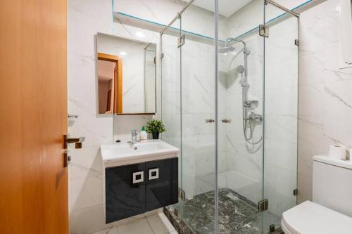 a bathroom with a glass shower and a sink at TT Holidays Cosy apartment Rabat City Center in Rabat
