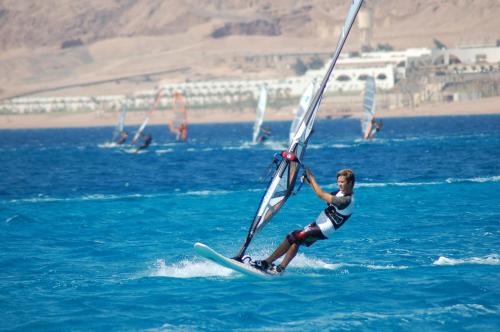 a man on a surfboard in the water at Retac Qunay Dahab Resort & SPA in Dahab