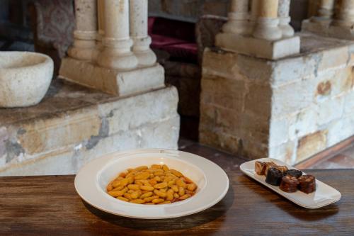 a bowl of peanuts and a plate of dates on a table at Parador de Cangas de Onís in Villanueva de Cangas de Onís