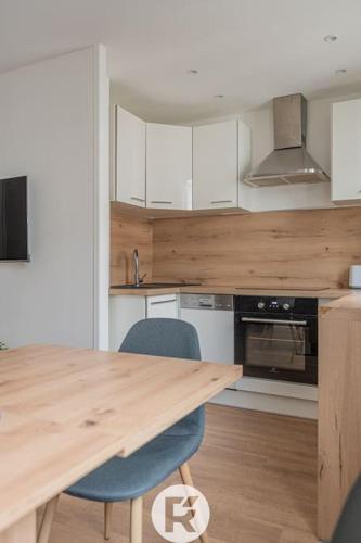 une cuisine avec une table en bois et deux chaises dans l'établissement R'Apparts T2 Refuge Chic, à Grenoble