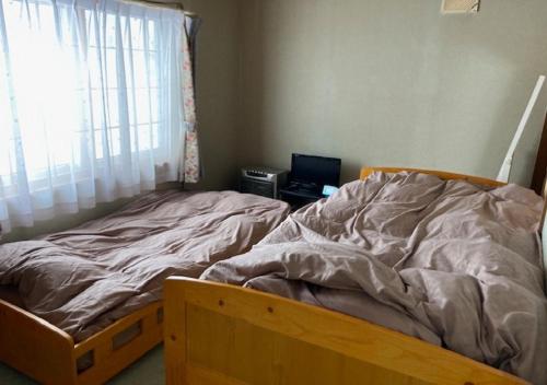 an unmade bed in a bedroom with a window at Otaru - House - Vacation STAY 87614 in Otaru