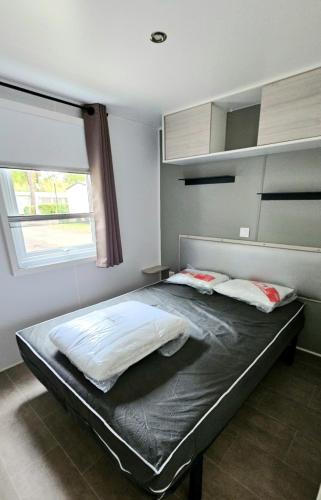 une chambre avec un grand lit avec une fenêtre dans l'établissement Mobile home n°261 2chambres à 2 pas du lac !, à Gastes