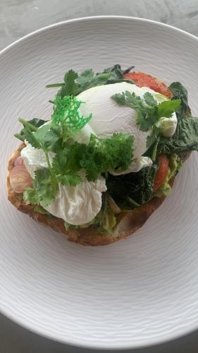 a sandwich with an egg on a white plate at Shanti Boutique Retreat in Tanah Lot