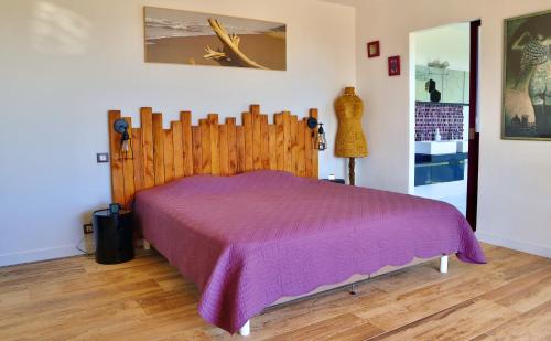 - une chambre avec un lit et une couverture violette dans l'établissement Villa Leana Villata, à Sainte-Lucie de Porto-Vecchio