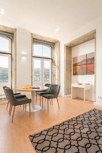 a living room with a table and chairs and windows at Romantic Douro River & Sunset views in Porto