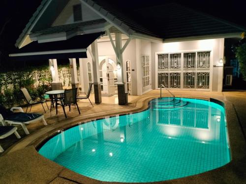 una piscina en un patio trasero por la noche en Beautiful Villa with private pool in Cha-Am, en Ban Sahakham