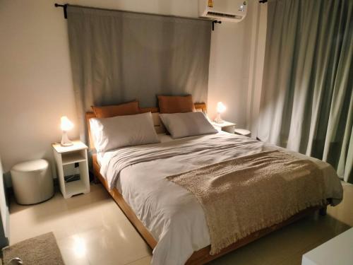 ein Schlafzimmer mit einem großen Bett mit zwei Lampen in der Unterkunft Beautiful Villa with private pool in Cha-Am in Ban Sahakham