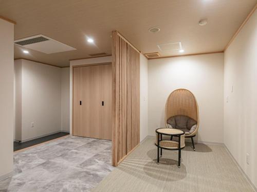 a room with a chair and a table and a door at Ureshino Motoyu in Ureshino