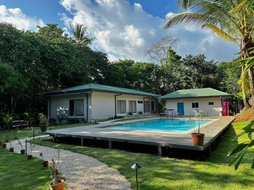 a house with a swimming pool in the yard at Marala Hotel in Esterillos