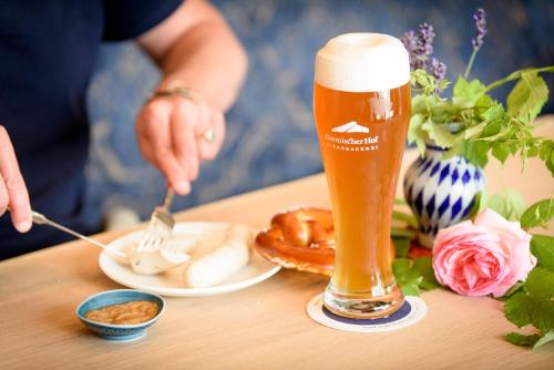 een persoon die een pretzel en een glas bier eet bij Biohotel Garmischer Hof in Garmisch-Partenkirchen