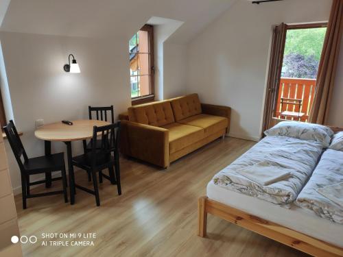 a bedroom with a bed and a table and a couch at Szklarska Chata in Szklarska Poręba