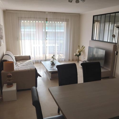 a living room with a couch and a table at la palme d or in Saint-Raphaël