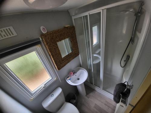 a small bathroom with a shower and a sink at 15 bluebell lane in Hastings
