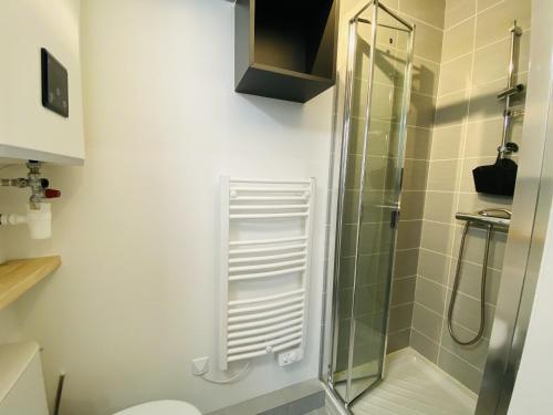 een badkamer met een douche en een glazen deur bij Le Bilongue in Rodez