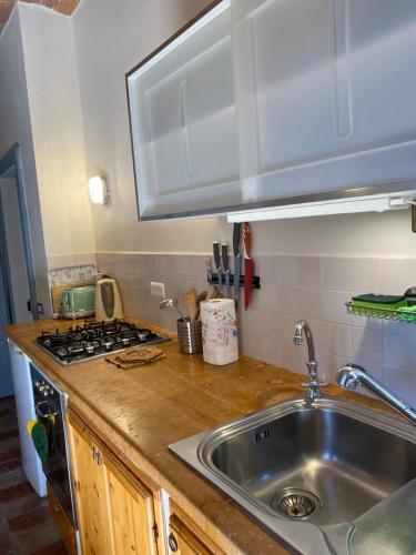 un bancone della cucina con lavandino e piano cottura di La Casetta a Pievina