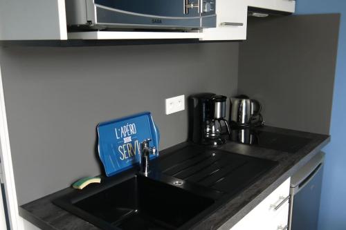 d'un comptoir de cuisine avec un évier et un panneau. dans l'établissement Appart plein sud face VUE MAGNIFIQUE : Ile d'Artz, à La Bernerie-en-Retz