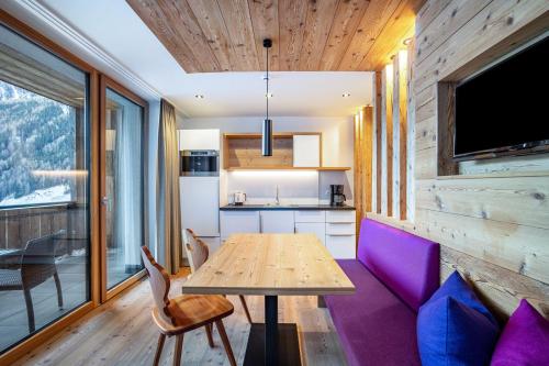 a dining room with a wooden table and purple chairs at Stoana Apt 1-1 in San Giacomo