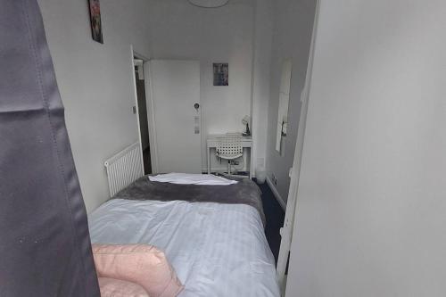 een kleine slaapkamer met een bed en een wastafel bij 3-Bed Apartment in King's Cross Central London in Londen