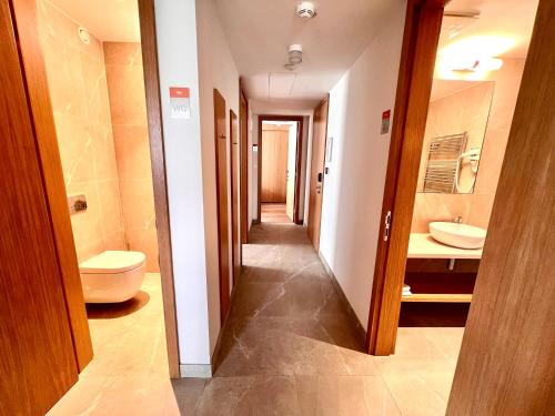 a hallway of a bathroom with a toilet and a sink at RAJ zdravia in Bratislava