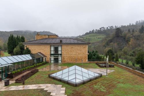 a brick building with a glass greenhouse in front of it at Parador de Cangas de Onís in Villanueva de Cangas de Onís