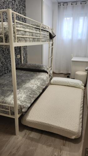 a bedroom with two bunk beds and a window at CASA VACACIONAL INDIVIDUAL 65mtr in Pinto