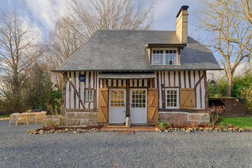 une petite maison avec un toit en gambrel dans l'établissement L'Écrin de Luxe, à Branville