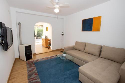 a living room with a couch and a tv at Garten und Pool in San Vicente del Raspeig