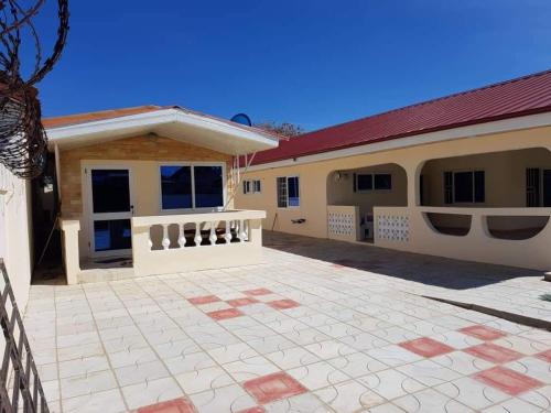 ein Haus mit einer Terrasse davor in der Unterkunft Bienvenue in Accra