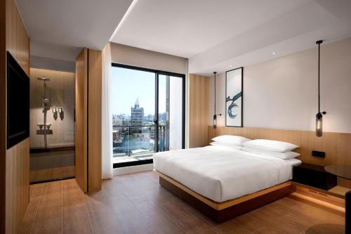 um quarto com uma cama branca e uma grande janela em Fairfield by Marriott Taichung em Taichung