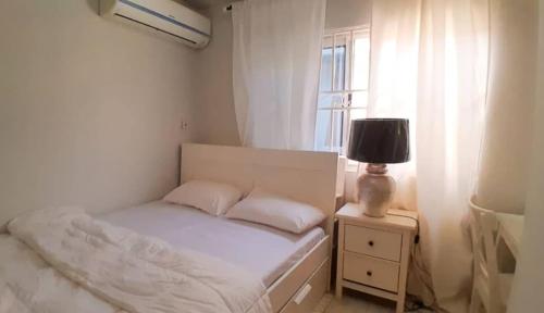 ein kleines Schlafzimmer mit einem Bett und einem Fenster in der Unterkunft Bienvenue in Accra