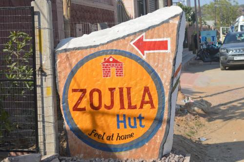 um sinal para uma cabana de zolilla ao lado de uma rua em Zojila hut em Jodhpur