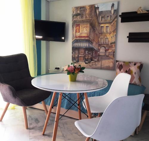 a table and chairs in a room with a painting at "La Vie Est Belle" by the sea Rethymno in Rethymno