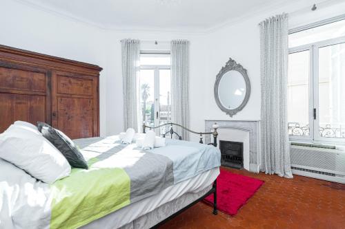 - une chambre avec un lit avec un miroir et une cheminée dans l'établissement 77 Avenue de Grasse, à Cannes