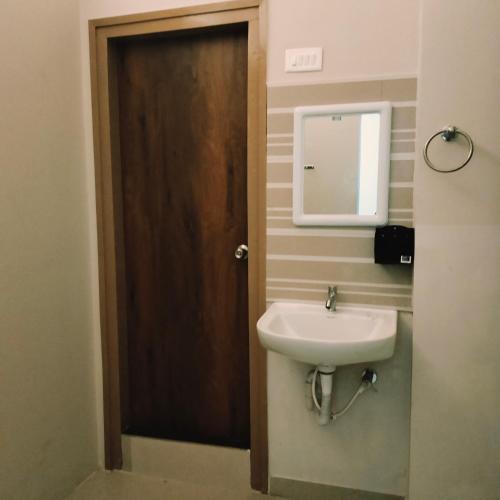 a bathroom with a sink and a mirror at NESTER HOMESTAY in Guwahati