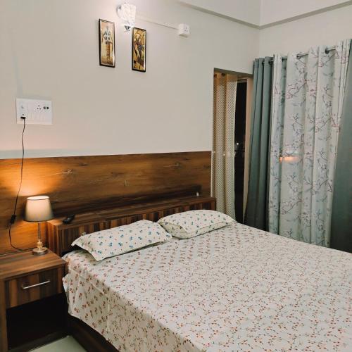 a bedroom with a bed with a wooden headboard at NESTER HOMESTAY in Guwahati