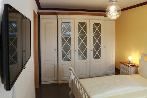 Schlafzimmer mit einem Bett und einem Schrank mit Glastüren in der Unterkunft Fewo on the Top in Willingen