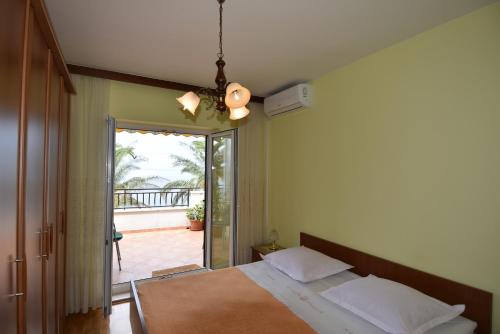 a bedroom with a bed and a view of a patio at Villa DELFINA 2 in Podgora