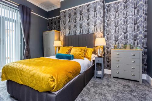 ein Schlafzimmer mit einem großen Bett mit gelber Tagesdecke in der Unterkunft Room 01 - Sandhaven Rooms - Double in South Shields