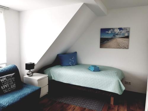 a small bedroom with a bed and a chair at FEWO Solingen Abendstrasse in Solingen