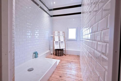 ein weißes Bad mit einer Badewanne und einem Fenster in der Unterkunft Maison de Champagne F.Barbier ! in Avize