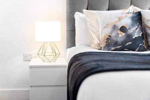 a bedroom with a bed with a pillow and a lamp at The Marsons Collection - 2 Bedrooms Apartment - Balcony - Secure Parking - 1MC in Birmingham