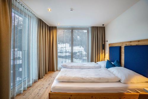 a bedroom with two beds and a large window at Stoana Apt 3-1 in San Giacomo