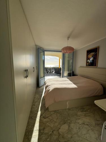 une chambre avec un grand lit et une grande fenêtre dans l'établissement P3 Monaco vue mer, à Roquebrune-Cap-Martin