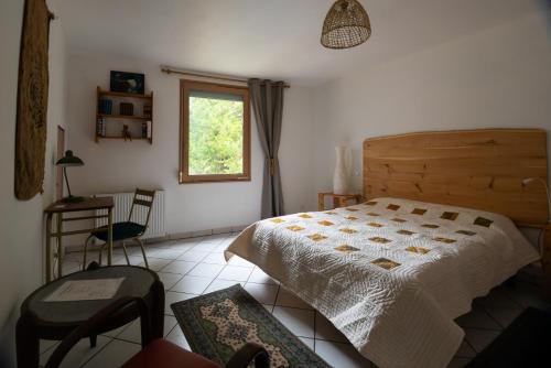 a bedroom with a bed and a window and a chair at chambre indépendante dans le moulin in Pouilly-sur-Vingeanne
