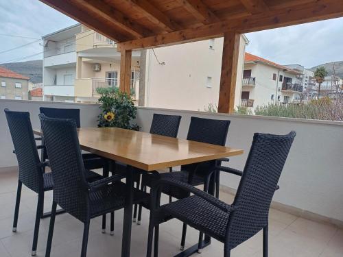a wooden table and chairs on a balcony at Apartments Grdelin in Trogir