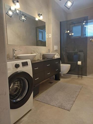 a bathroom with a washing machine and a sink at Apartments Grdelin in Trogir