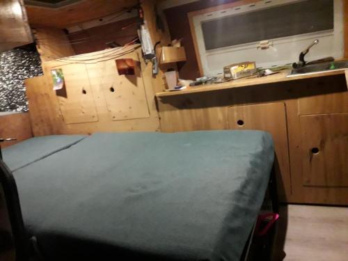 um quarto com uma cama e uma cozinha com um lavatório em Van à louer au pied des pistes em Bourg-Saint-Maurice
